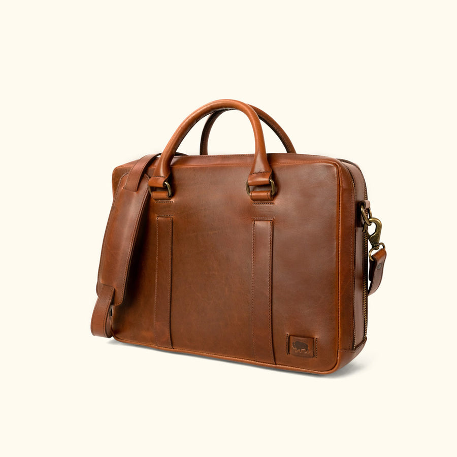 Executive-style tan leather briefcase, featuring a smooth exterior and robust carrying options.