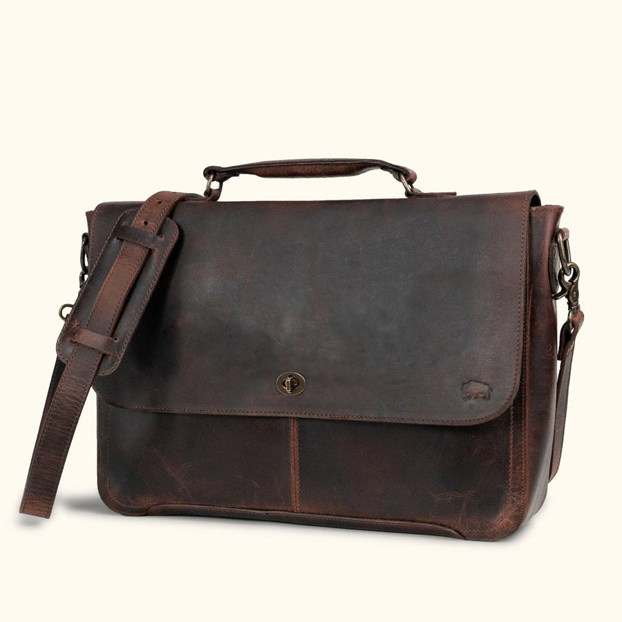 Vintage dark brown leather messenger bag with aged patina, featuring sturdy handle, adjustable strap, and classic front buckle closure.