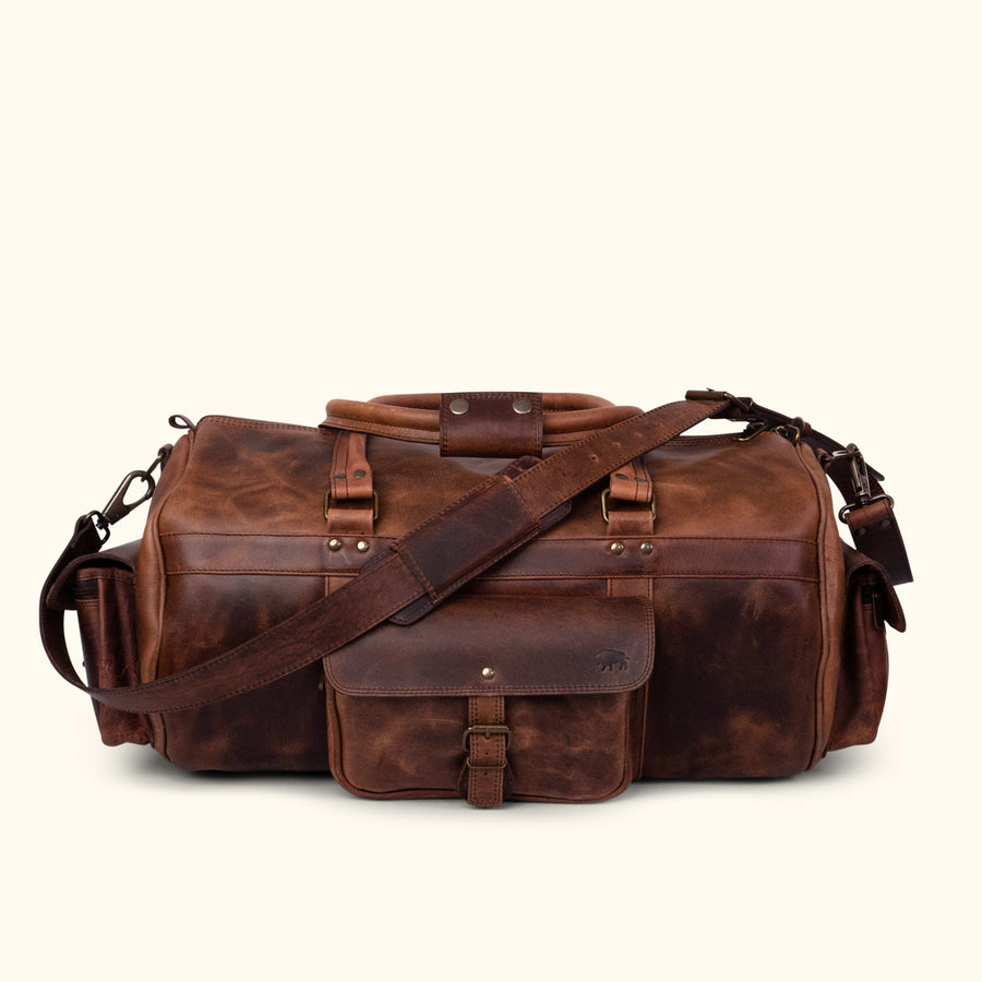 Buffalo leather duffle bag featuring multiple compartments, adjustable shoulder strap, and sturdy handles for travel and daily use.
